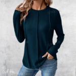 Teal long-sleeve top featuring a classic round neckline, fitted silhouette and subtle shoulder detailing.