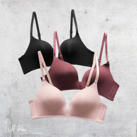 Essential Comfort Wireless T-Shirt Bra in blush pink, black and burgundy with smooth cups and adjustable straps.
