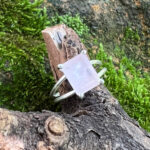 The Rose Quartz Emerald Cut Ring is a delicate and elegant statement piece featuring a soft pink rose quartz stone in a striking emerald-cut shape. Set within a sleek silver-toned setting, the clean lines of the stone create a beautiful balance between modern style and natural gemstone charm. The soft blush tone of the rose quartz gives this ring a feminine and sophisticated appearance, while the rectangular emerald cut adds a refined, contemporary touch. Its minimalist setting allows the gemstone to remain the star of the piece, making it an easy accessory to wear on its own or alongside other delicate jewellery. Perfect for everyday wear, special occasions or adding a subtle pop of colour to your jewellery collection, the Rose Quartz Emerald Cut Ring is a versatile piece that can complement a variety of personal styles. Product Features - Soft pink rose quartz stone - Elegant emerald-cut design - Sleek silver-toned setting - Feminine and sophisticated appearance - Modern geometric silhouette - Nature-inspired gemstone appeal - Versatile for everyday or occasion wear - Beautiful statement piece for any jewellery collection Add a soft, romantic touch to your look with the Rose Quartz Emerald Cut Ring — a timeless piece that beautifully combines the natural appeal of rose quartz with a clean and elegant geometric design.