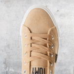 Beige Tomy Sneaker featuring a textured beige upper, matching lace-up design, silver eyelets and a contrasting white rubber sole.