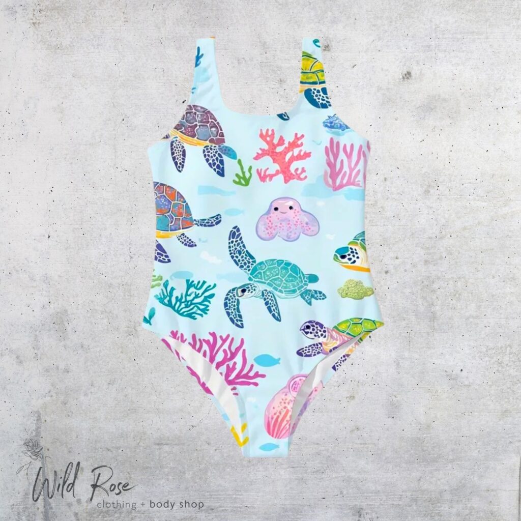 Under the Sea Swimsuit featuring colourful sea turtles and coral prints on a pastel blue background, perfect for children's beach days and swimming adventures.