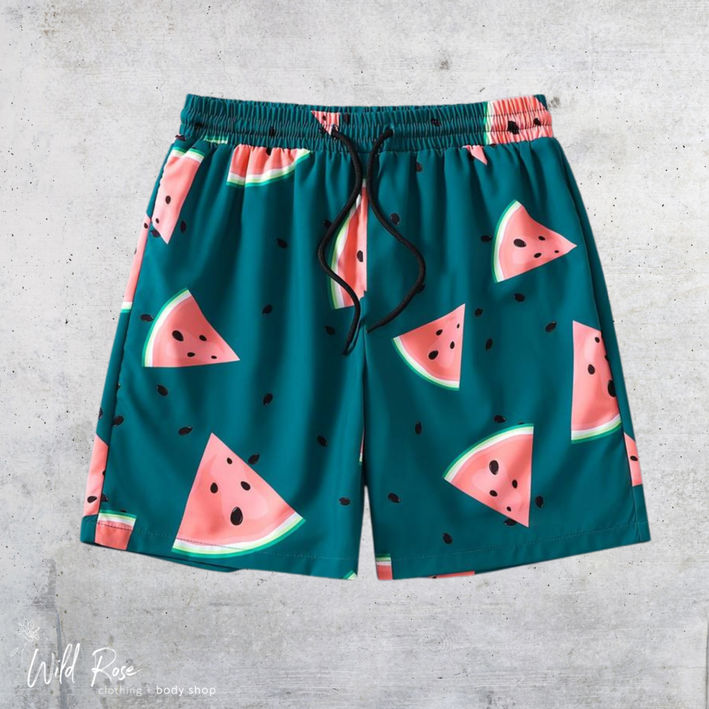 Watermelon Print Swim Shorts featuring pink watermelon slices on a teal background, with an elasticated waistband and adjustable drawstring.