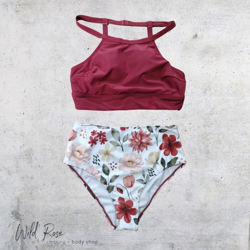 Ladies Rust & White Floral Bikini Set featuring a rust-red bikini top with stylish shoulder straps and matching white bikini bottoms decorated with a colourful floral print.