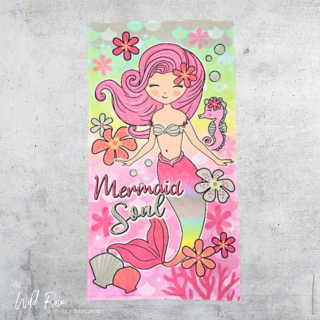 Mermaid Beach Towel featuring a pink-haired mermaid with a pink tail, surrounded by colourful flowers, seashells and pastel ocean-inspired details on a light green and pink background.