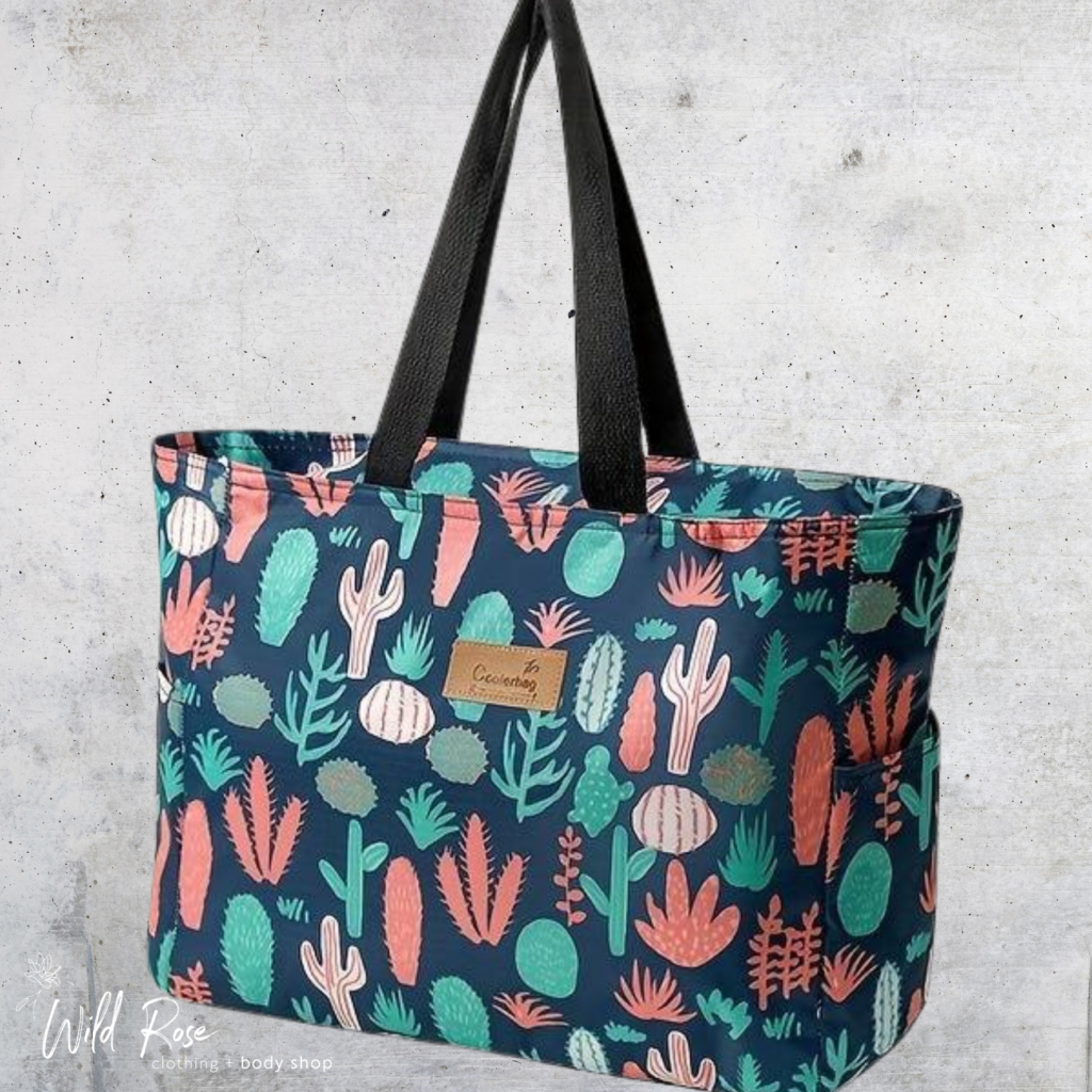 Desert Bloom Cooler Bag featuring a colourful cactus and botanical print on a teal background with sturdy black shoulder straps.