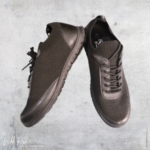 Ladies black Hush Puppies sneakers featuring mesh detailing, lace-up fastening, and a sleek sporty design.