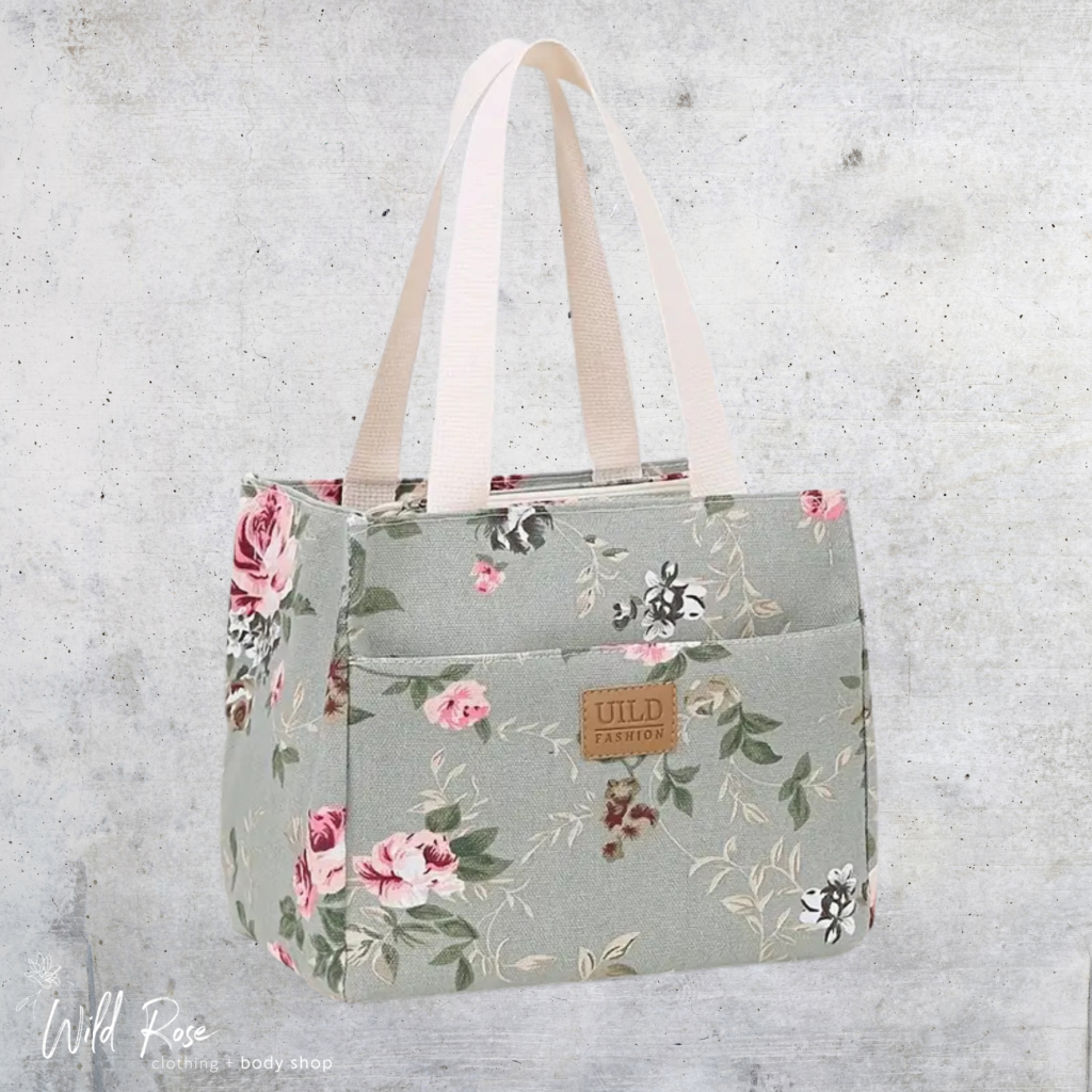 Wild Petal Lunch Bag featuring a beautiful pink rose and botanical print on a grey-green background with light-coloured tote handles.