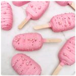 Yummy Treats LolliCake pink cake pops on sticks decorated with drizzled icing and sprinkles, perfect for parties and dessert tables.