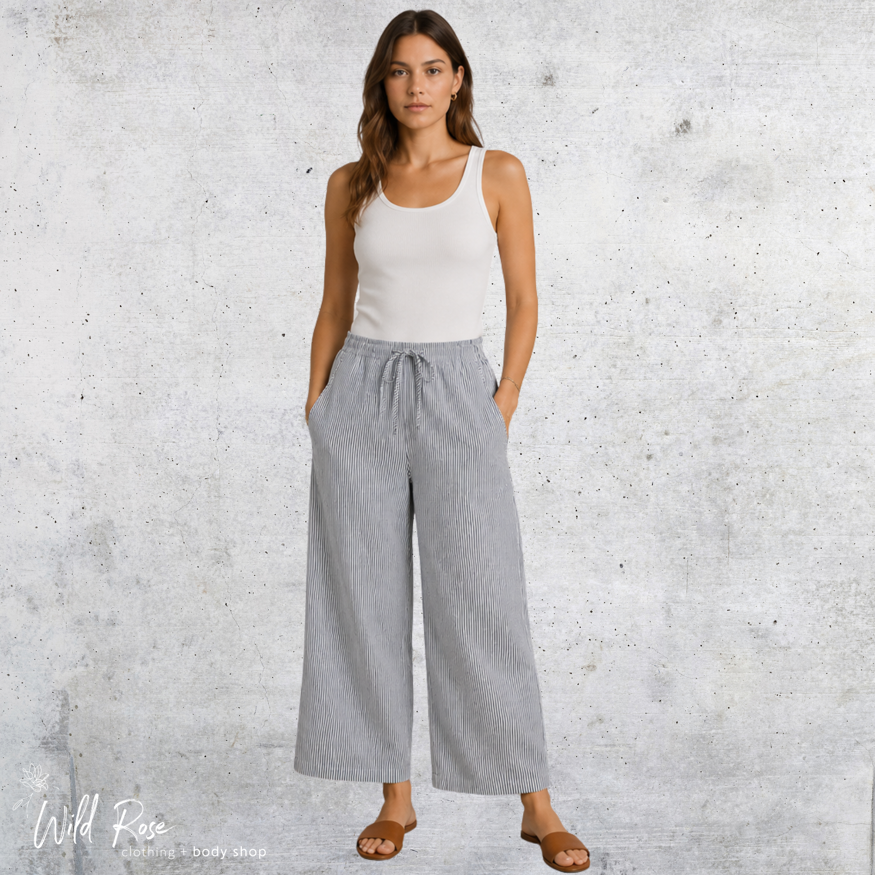Grey Pinstripe Wide-Leg Pants for Women Woman wearing grey pinstripe wide-leg pants with a white sleeveless top and sandals.