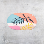 Oval Rubber Bath and Shower Mat with colourful abstract botanical design in pink, peach, blue, white and gold.