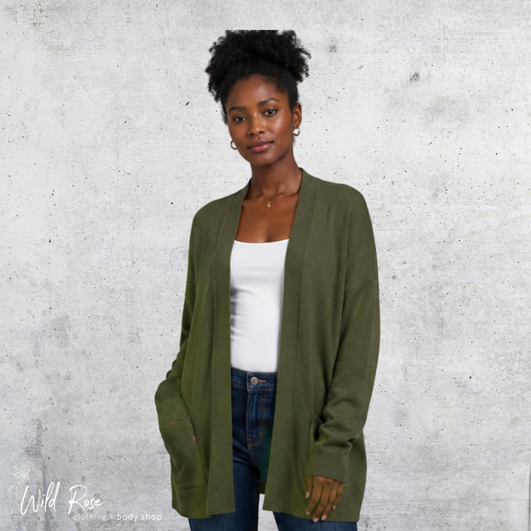 Olive Open Knit Cardigan – Women’s Olive Green Cardigan Woman wearing an olive-green open knit cardigan over a white top and blue jeans.