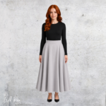 Woman wearing a soft taupe winter skirt with a flowing full-length silhouette, paired with a black long-sleeve top.
